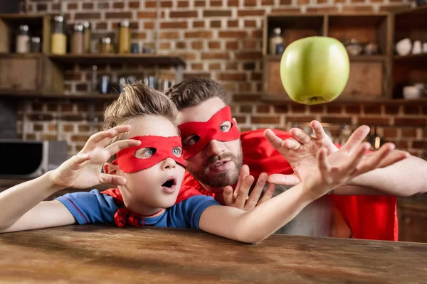 Far och son i röda superhjälte dräkter — Stockfoto