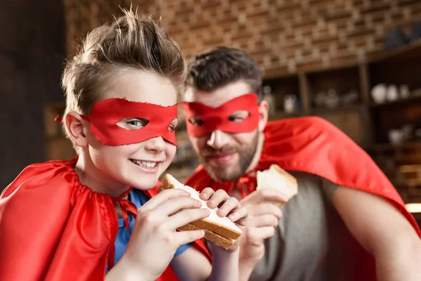 Pai e filho comendo sanduíches — Fotografia de Stock