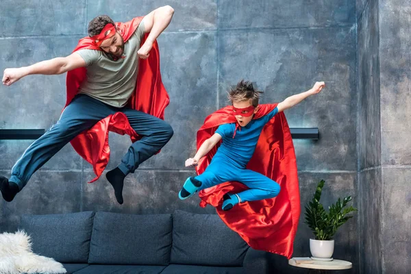 Far og søn i superhelt kostumer Royaltyfrie stock-billeder