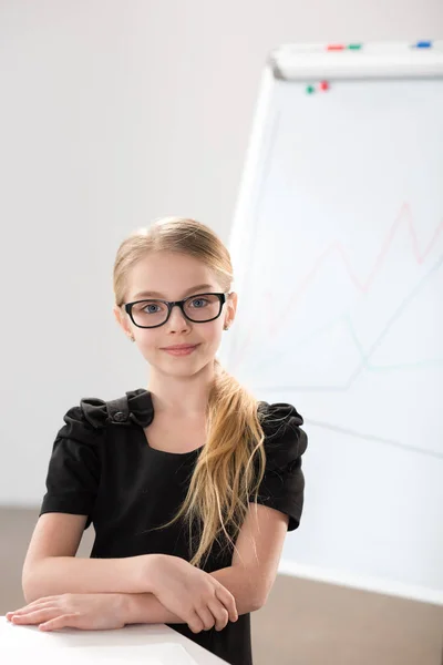 Klein meisje zitten aan tafel — Stockfoto