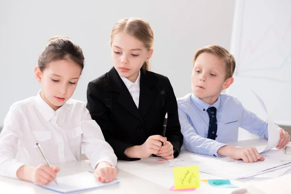 Schattige kinderen werken met papieren — Stockfoto