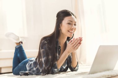 woman lying on carpet and clapping hands clipart