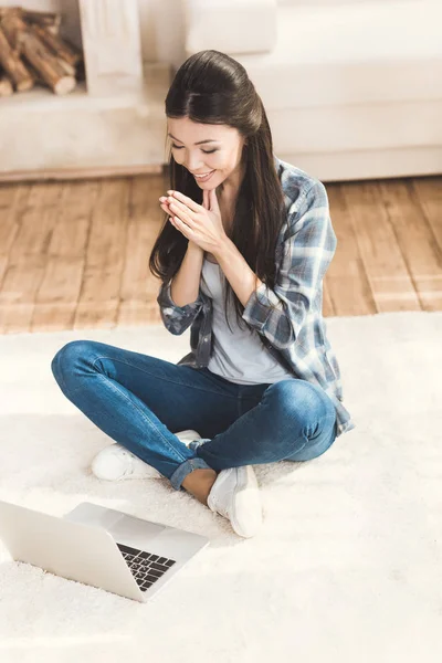 Woman sitting on carpet and clapping hands — Stock Photo, Image