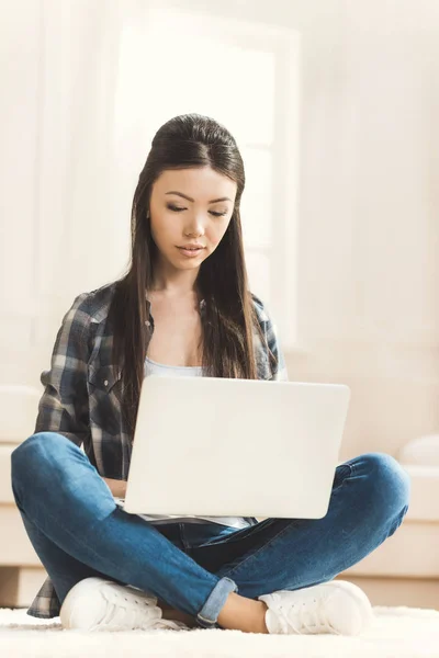 Mulher sentada no chão e trabalhando no laptop — Fotografia de Stock