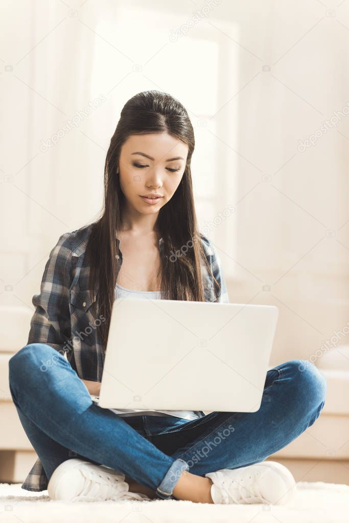 Front view of pretty woman sitting on floor and working on laptop computer stock vector