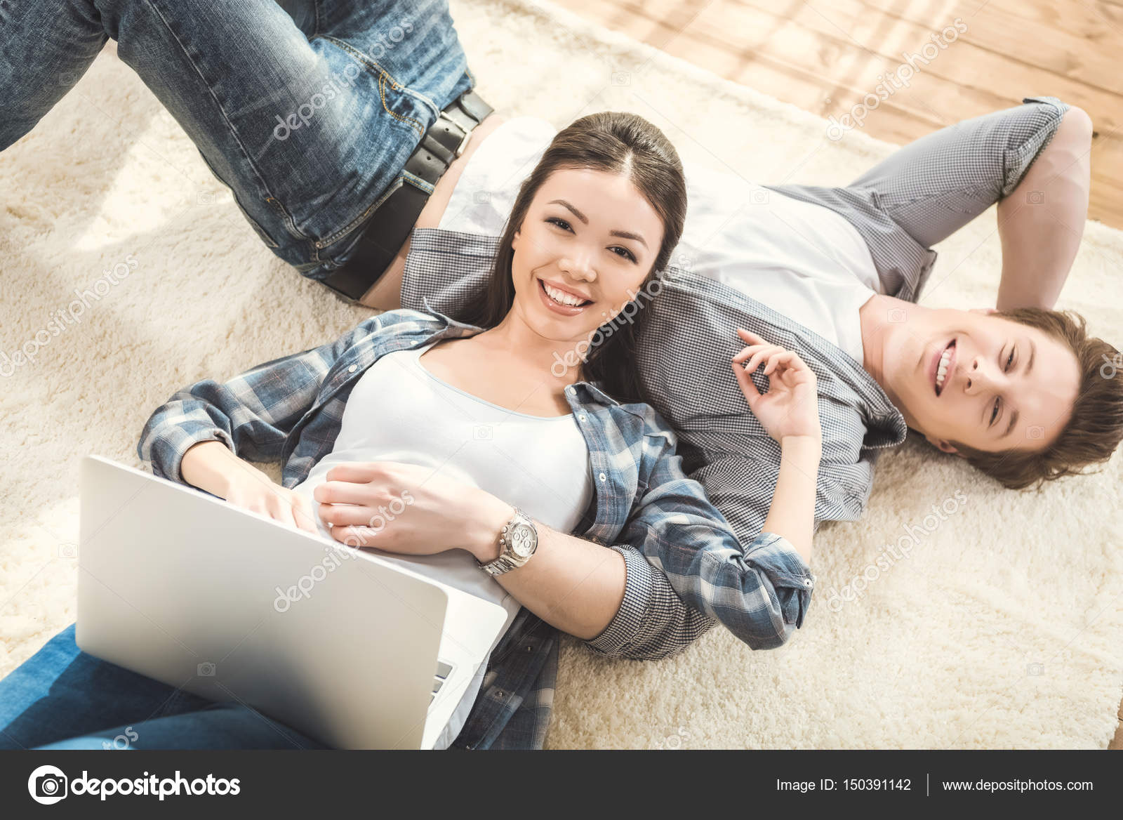 Femme couché sur petit ami et en utilisant un ordinateur portable image libre de droit par