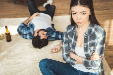 woman sitting on floor near drunk boyfriend clipart