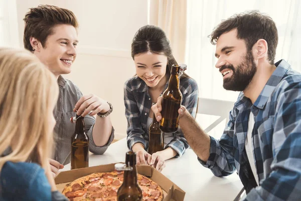Parejas bebiendo cerveza y comiendo pizza — Foto de Stock