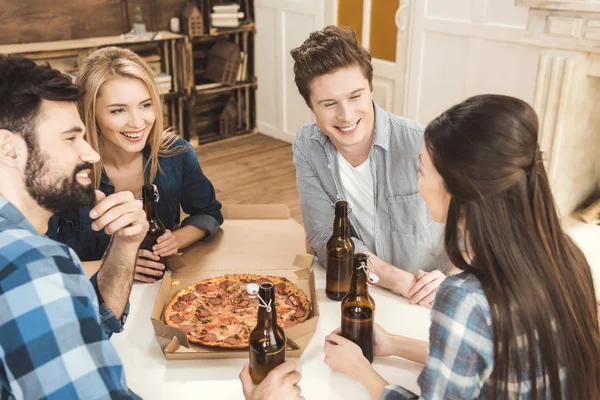Couples drinking beer and eating pizza — Stock Photo, Image