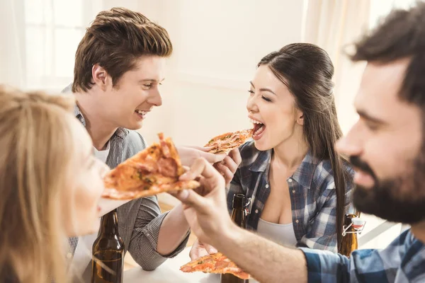 Parejas bebiendo cerveza y comiendo pizza — Foto de Stock