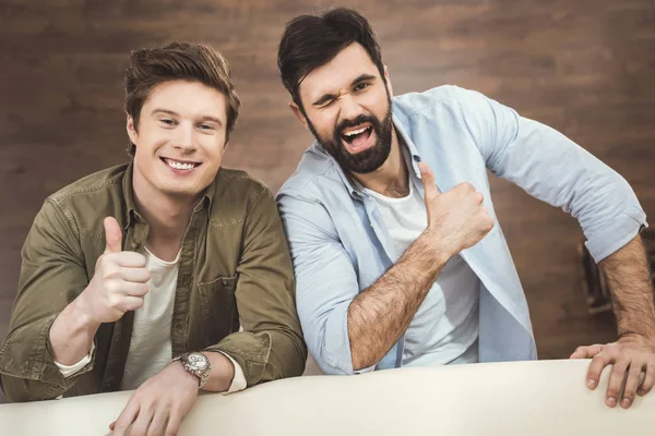 Two young men leaning on sofa — Stock Photo, Image