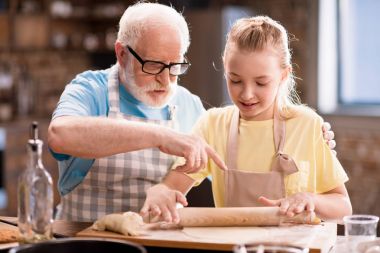 grandfather and granddaughter making dough clipart