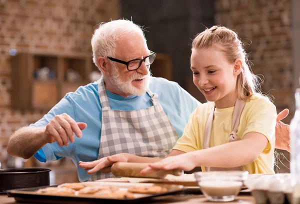 Grand-père et petite-fille pétrissant la pâte — Photo