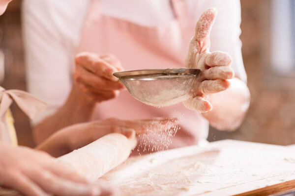 Grandmother and grandchild kneading dough 