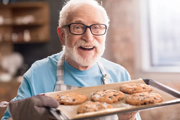 Starší muž se soubory cookie — Stock fotografie