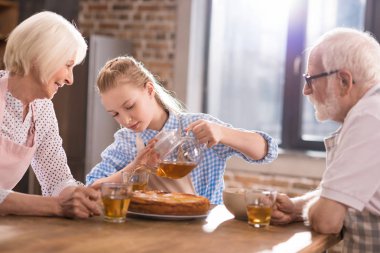 Aile evde çay içiyor.