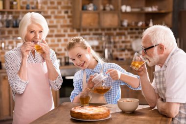 Aile evde çay içiyor.