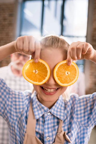 Дівчина тримає апельсинові скибочки — стокове фото