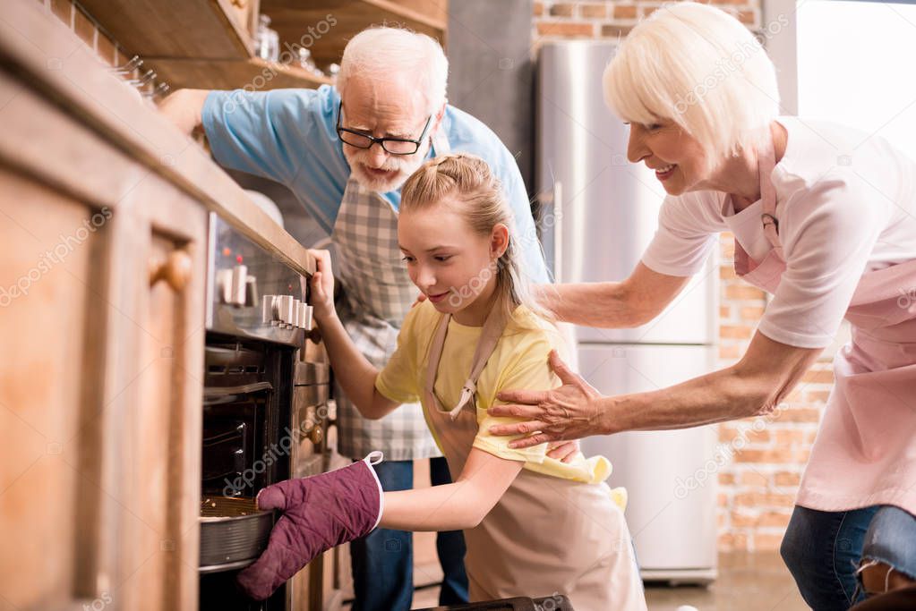 girl placing pie in oven