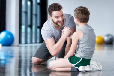 Boy with young man at fitness center
