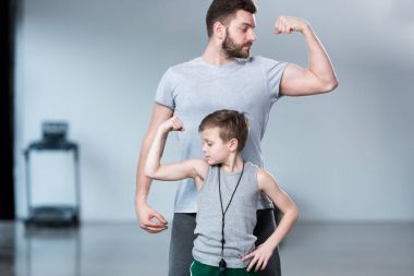 Genç adam kas gösterilen çocukla 