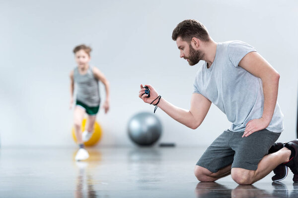 Boy exercising with his coach