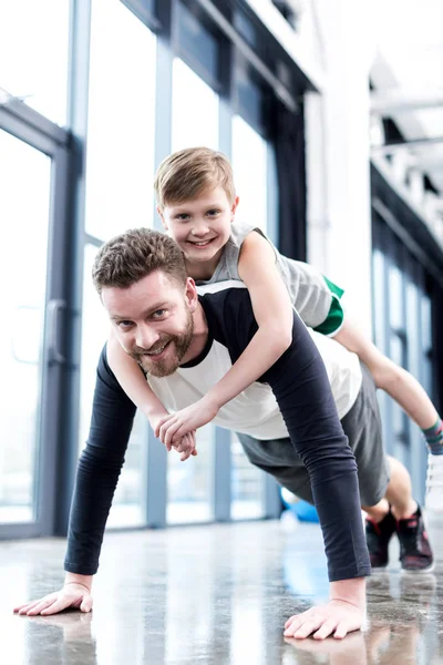 Hombre haciendo flexiones con chico —  Fotos de Stock