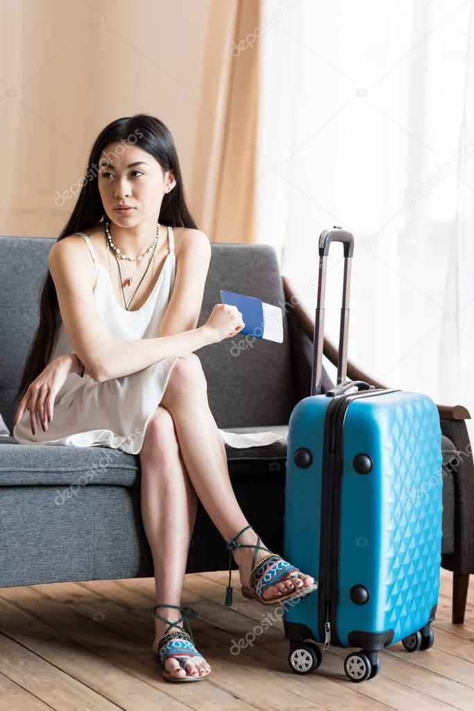 asian woman traveler sitting with suitcase