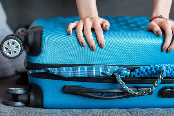 Руки, що тримають перевантажену валізу — стокове фото