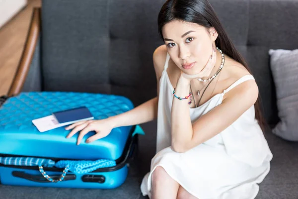 Asian woman traveler sitting with suitcase — Stock Photo, Image