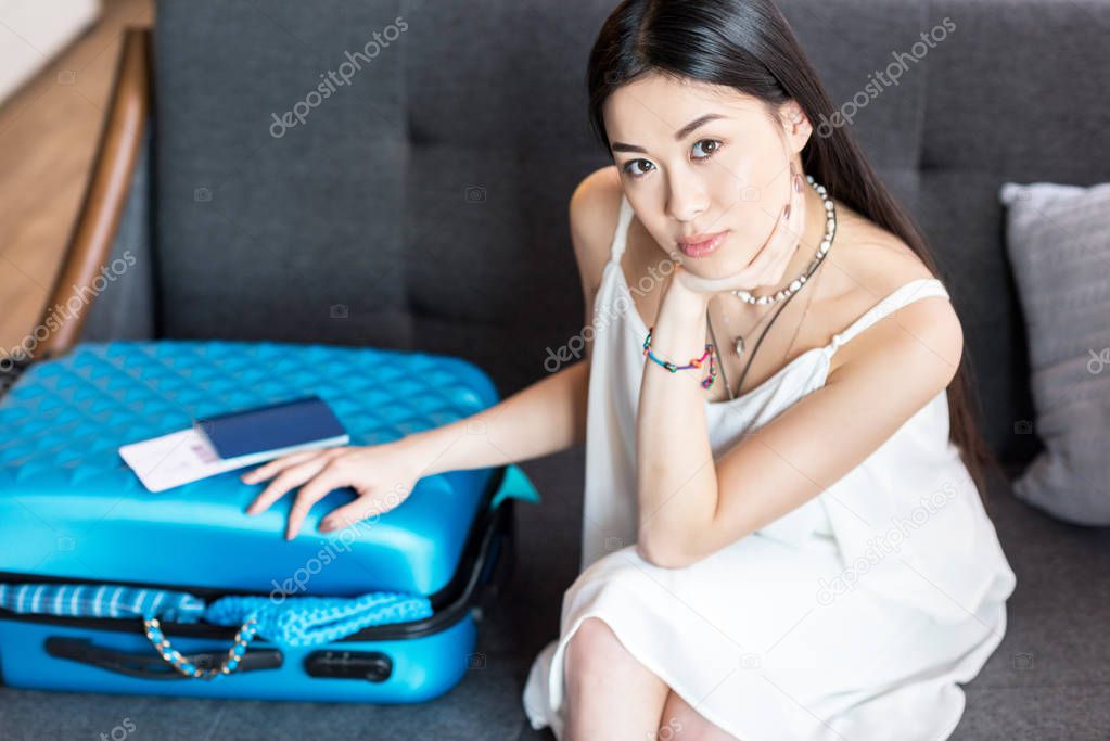 asian woman traveler sitting with suitcase