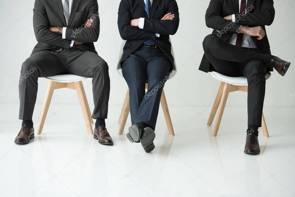 businessmen sitting on chairs