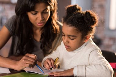 Mother with daughter doing homework  clipart