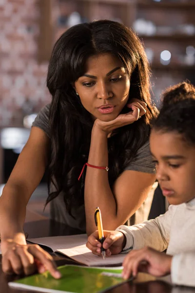 Mère avec sa fille faisant ses devoirs — Photo