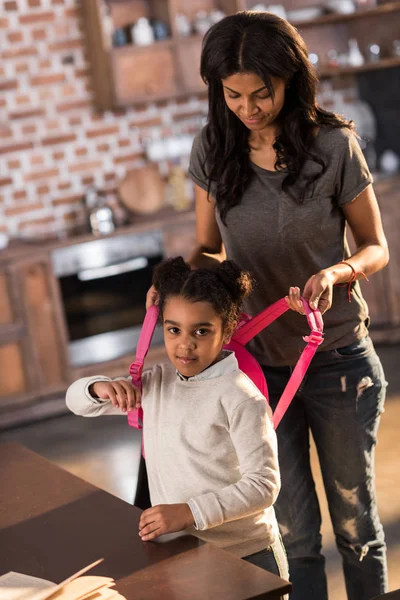 Mother helping daughter with backpack — Stock Photo, Image