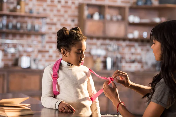 Madre ayudando a hija con mochila — Foto de Stock