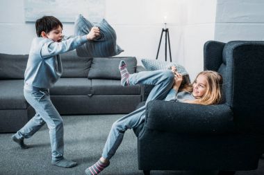 Siblings fighting with pillows  clipart