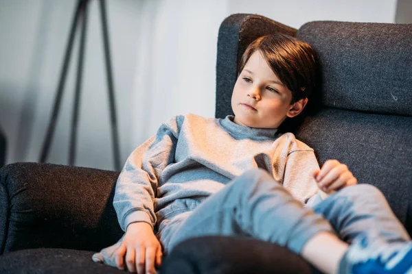 Boy sitting in armchair — Stock Photo, Image