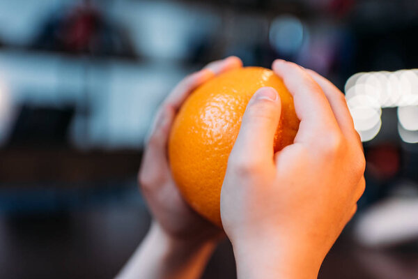 kid girl holding ripe orange