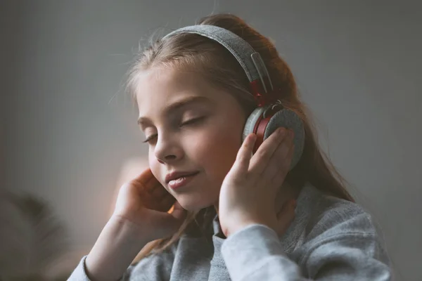 Παιδί κορίτσι ακούγοντας μουσική στα ακουστικά — Φωτογραφία Αρχείου