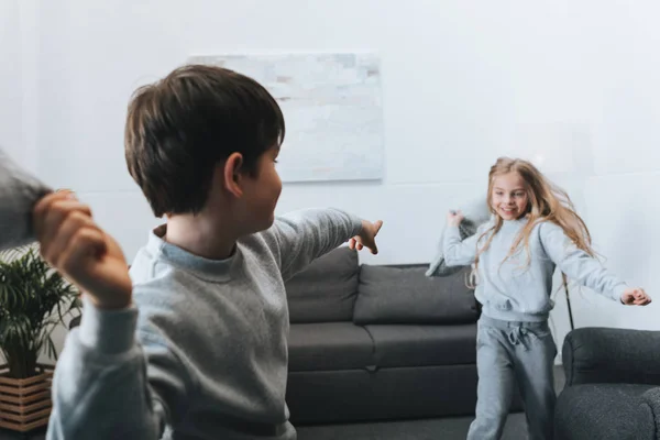 Menino e menina travesseiro luta em casa — Fotografia de Stock