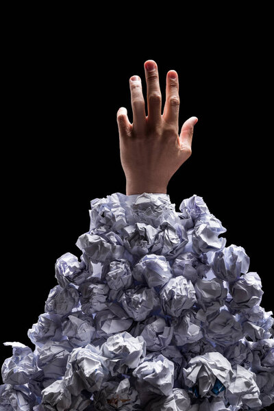 Hand reaching out from heap of papers