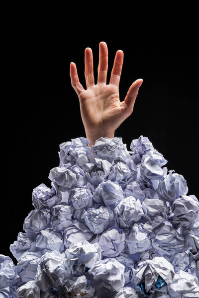 Hand reaching out from heap of papers