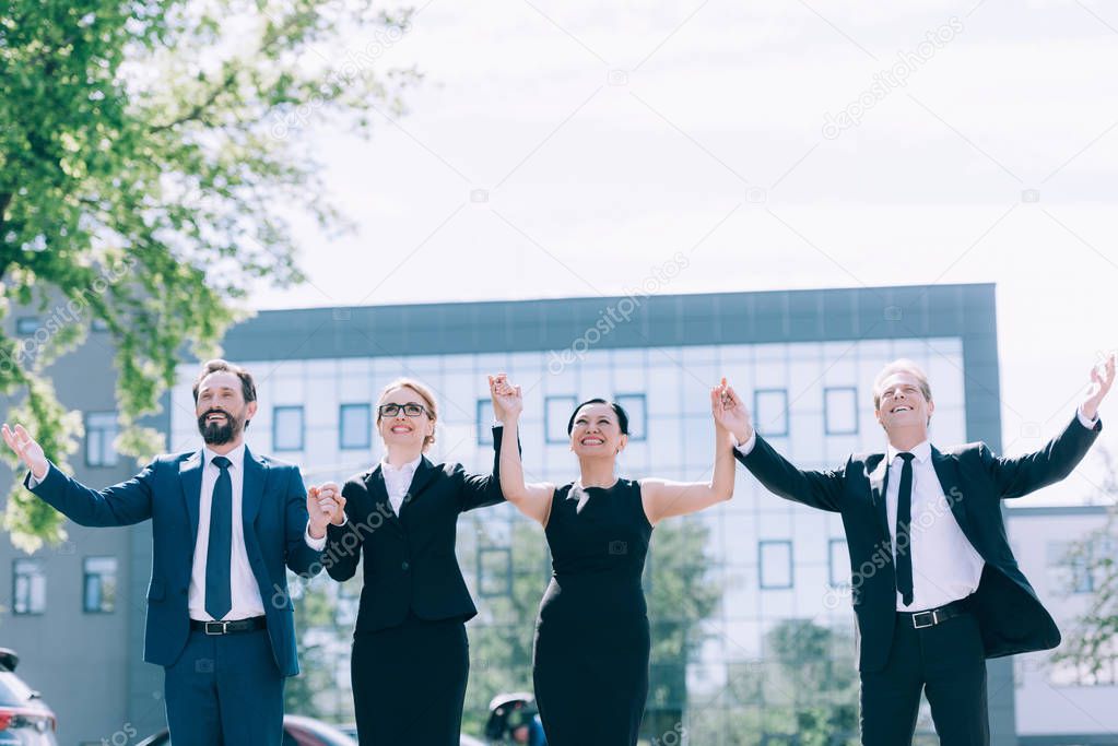 multiethnic businesspeople holding hands