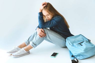 üzgün genç smartphone ve sırt çantası ile