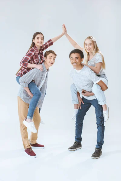 Multicultural teenagers piggybacking together — Stock Photo, Image