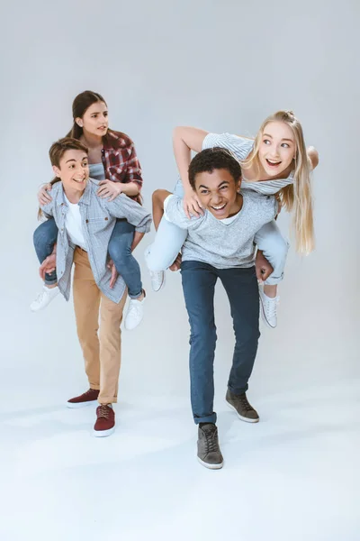 Multicultural teenagers piggybacking together — Stock Photo, Image