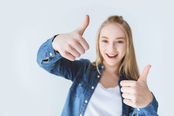 smiling teen girl showing thumbs up