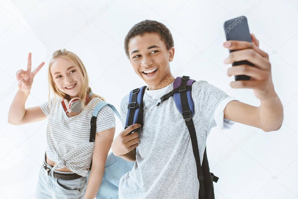 multicultural teenagers taking selfie