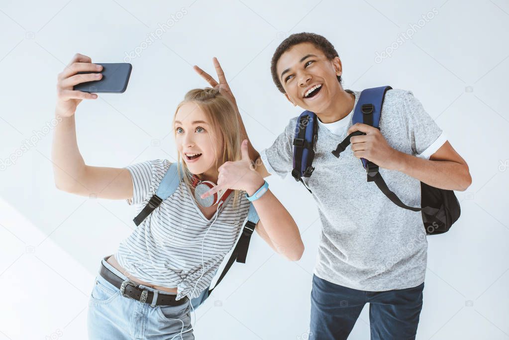 multicultural teenagers taking selfie
